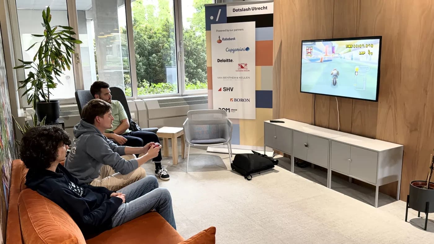 Three visitors playing Mario Kart Wii in the lobby of Dotslash Utrecht